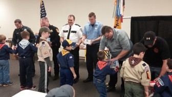 Cub Scouts present popcorn to local first responders, who were invited to attend their end-of-the-year awards ceremony and pizza party at New Jerusalem Evangelical Lutheran Church in Lower Saucon Township Dec. 19.