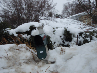 A damaged mailbox surrounded by deep snow (FILE PHOTO)