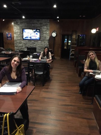 Managers at Taps Tavern prepare for the restaurant's grand opening by stuffing menus.