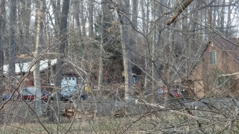 Fire scene investigators are visible through the trees in the 2500 block of Apple Street, Lower Saucon Township, where a man was found dead when crews responded to a brush fire Monday.