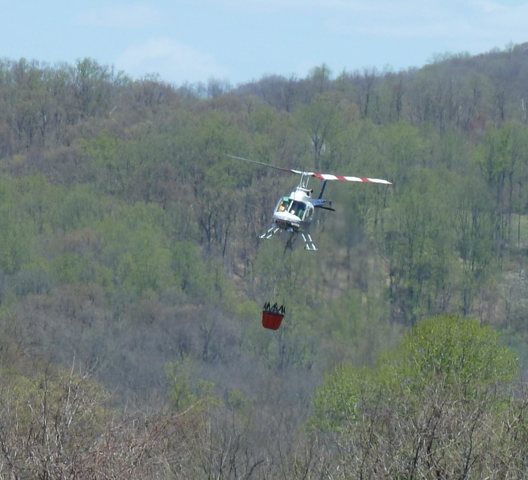 A helicopter drops water on a large brush fire near Lower Saucon Road and Kefallonia Drive in eastern Lower Saucon Township.