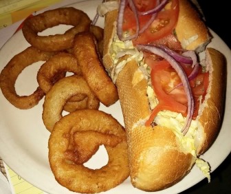 A California cheesesteak served with a side of onion rings at Cafe Erica.