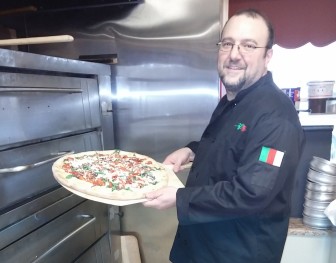 Cafe Erica and Bella's Ristorante chef-owner Vinny Cavataio prepares to put a gourmet goat cheese pizza in the oven at the cafe.