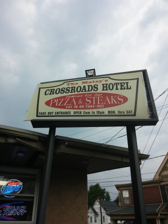 A large sign mounted on metal posts by the Crossroads Hotel pickup window was damaged when a car struck it Monday afternoon.