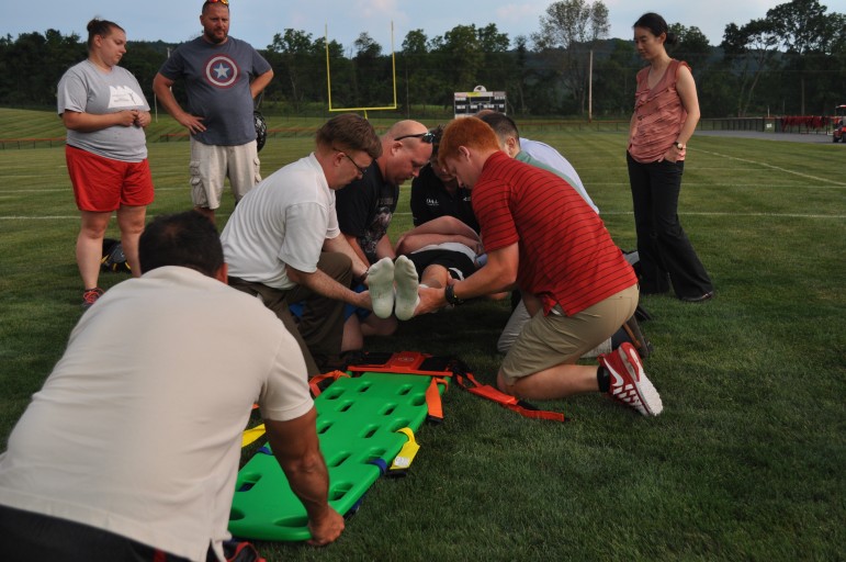 The "lift-and-slide" stabilization technique is demonstrated at a training exercise Monday at Saucon Valley School District Stadium.