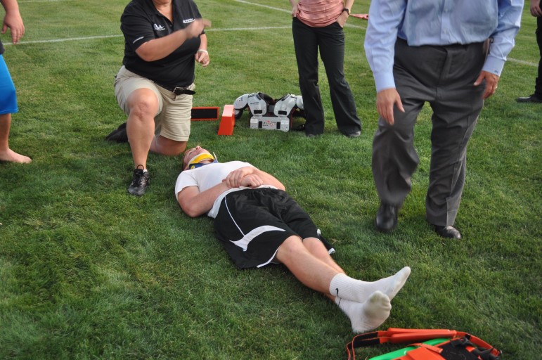 Trainer Amy demonstrates on student-athlete volunteer Christian Carvis.