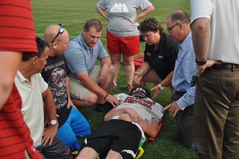 Volunteer student-athlete Christian Carvis is stabilized after being rolled onto a spine-board.