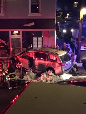 Police and other emergency personnel respond to the scene of an accident at Main and Saucon streets in Hellertown Sunday night. A minivan apparently damaged the entrance to a salon at the corner of Main and W. Saucon streets.