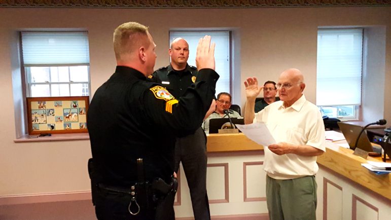 Sgt. Jeff Johnston, left, takes an oath of service administered by Hellertown Mayor Richard Fluck as Police Chief Robert Shupp looks on.