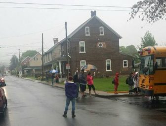 Rebecca Walser stands in the intersection of W. High and Whitaker streets in Hellertown to help prevent motorists from driving past her children's stopped school bus. Walser says a police presence is sorely needed at the bus stop in the mornings.