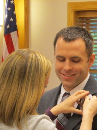 Lower Saucon Township Part-Time Police Patrolman John Krchnavy has his police badge pinned on by his wife Lisa.