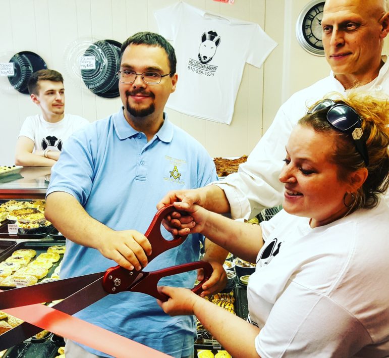 Hellertown-Lower Saucon Chamber of Commerce board chairman/borough council president Tom Rieger helps Hellertown Bakery owners Leiane McCarty and Joe Ciamprone cut the ribbon at their store Saturday morning. The bakery opened  for business in early April.