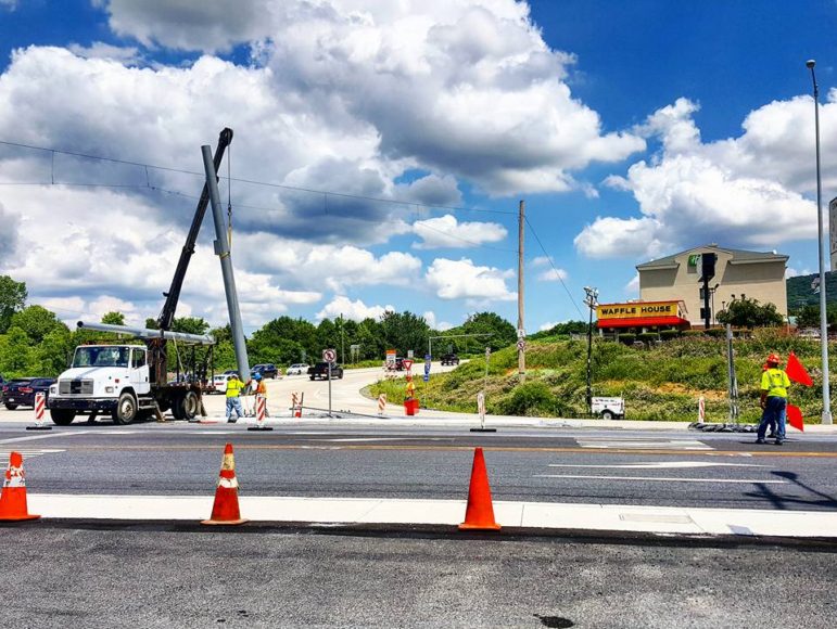 Workers erect a large metal pole on Rt. 412 at the entrance to the I-78 eastbound ramps in Hellertown Wednesday.