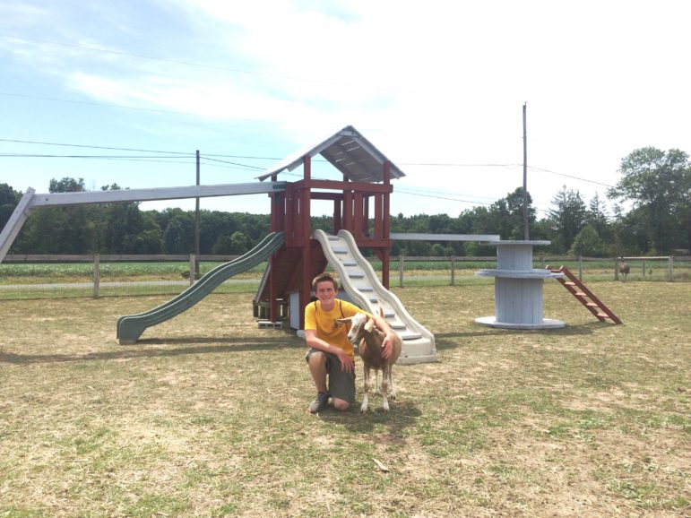 Ben Szydlow pets a four-legged friend at the goat playground he built as an Eagle Scout project at Last Chance Ranch Animal Rescue in Quakertown.