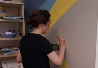 Hellertown artist Emily Graf works on a section of a large mural she painted on the second floor of the Hellertown Area Library, in the renovated Childrens Area.