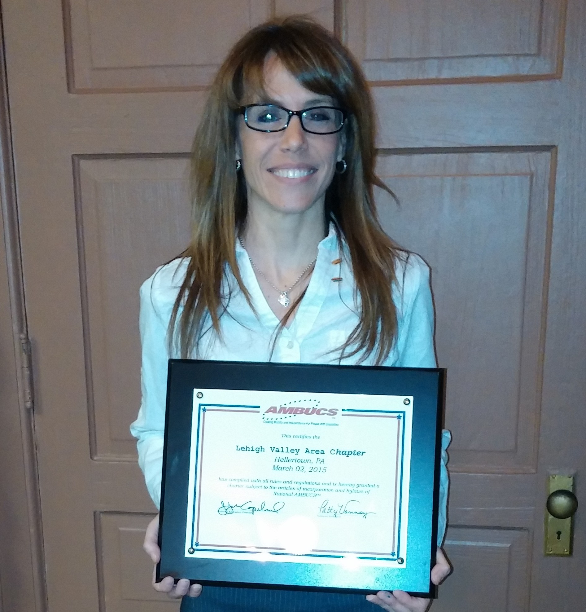Lehigh Valley Area AMBUCS President Lori Jardel holds the charter certificate for the newly-formed chapter. Jardel is leading the group during the transition from being the Saucon Valley Jaycees to AMBUCS, which is another service organization.