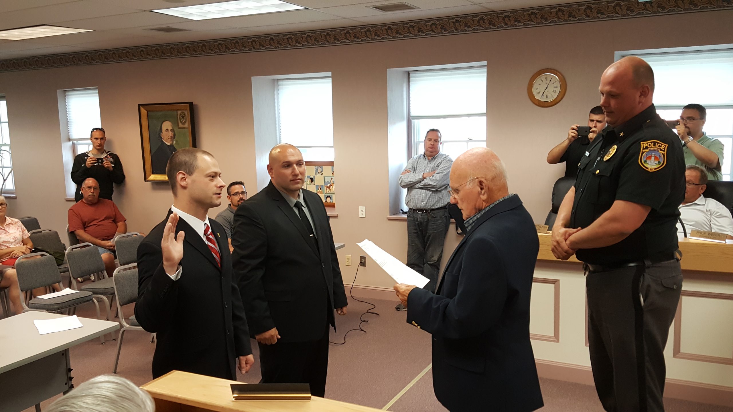 Cpl. Carl Fischer takes an oath of service administered by Hellertown Mayor Richard Fluck as Cpl. John Donato and Chief Robert Shupp look on.