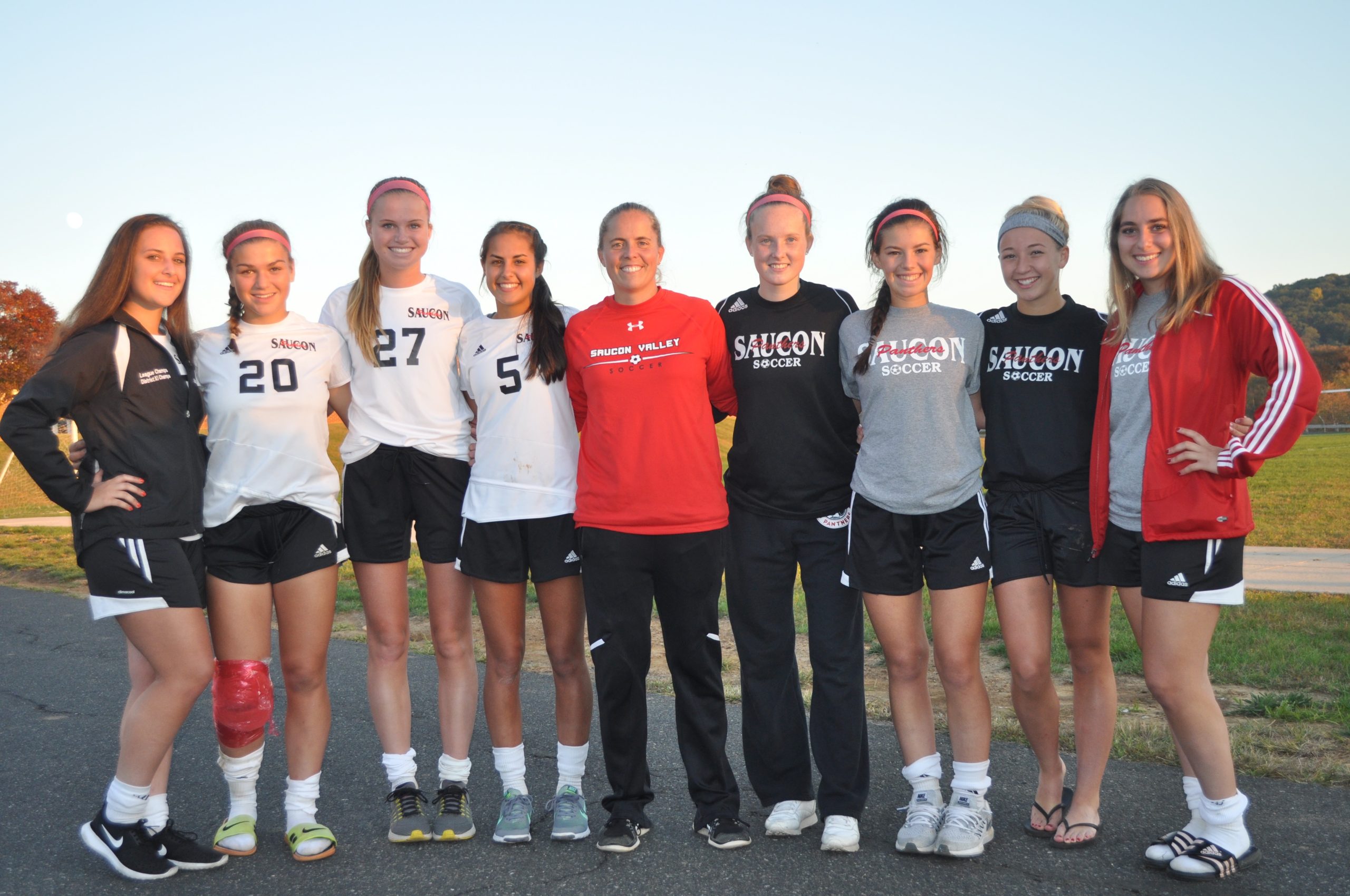 Coach Ochse takes a photo opportunity with her eight seniors.