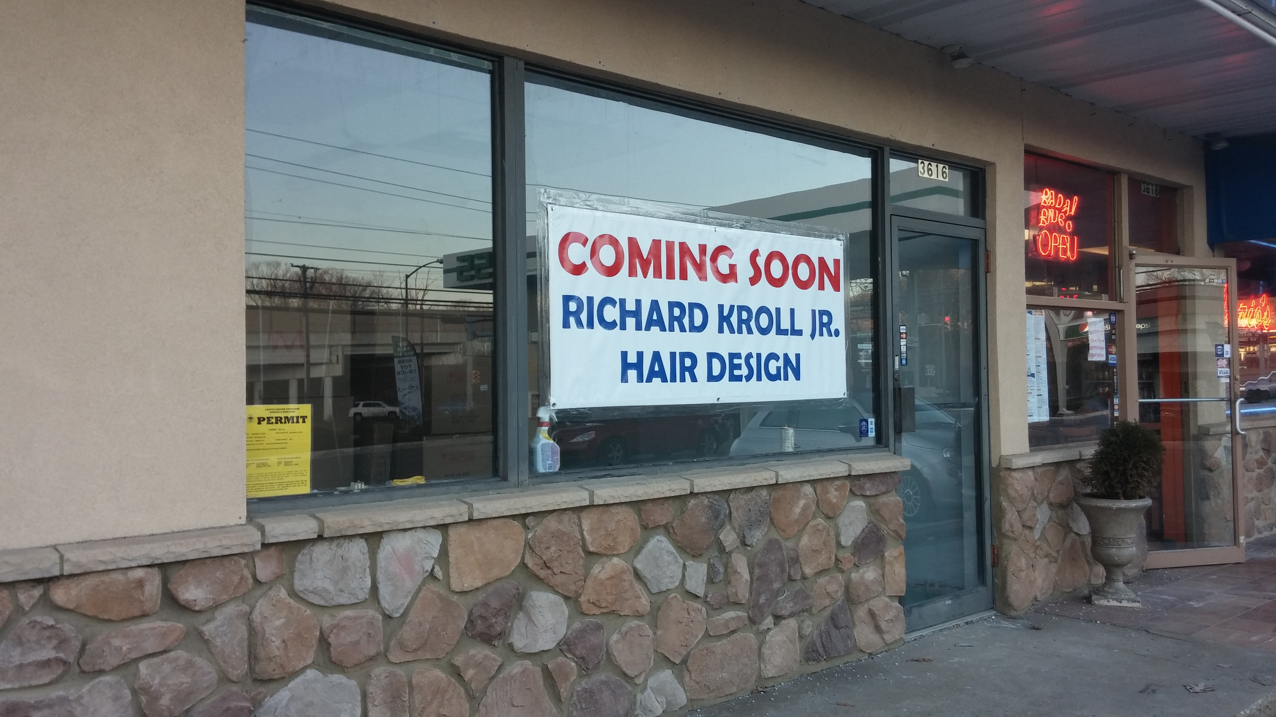 A sign promotes a new business in Black River Plaza--Richard Kroll Jr. Hair Design.