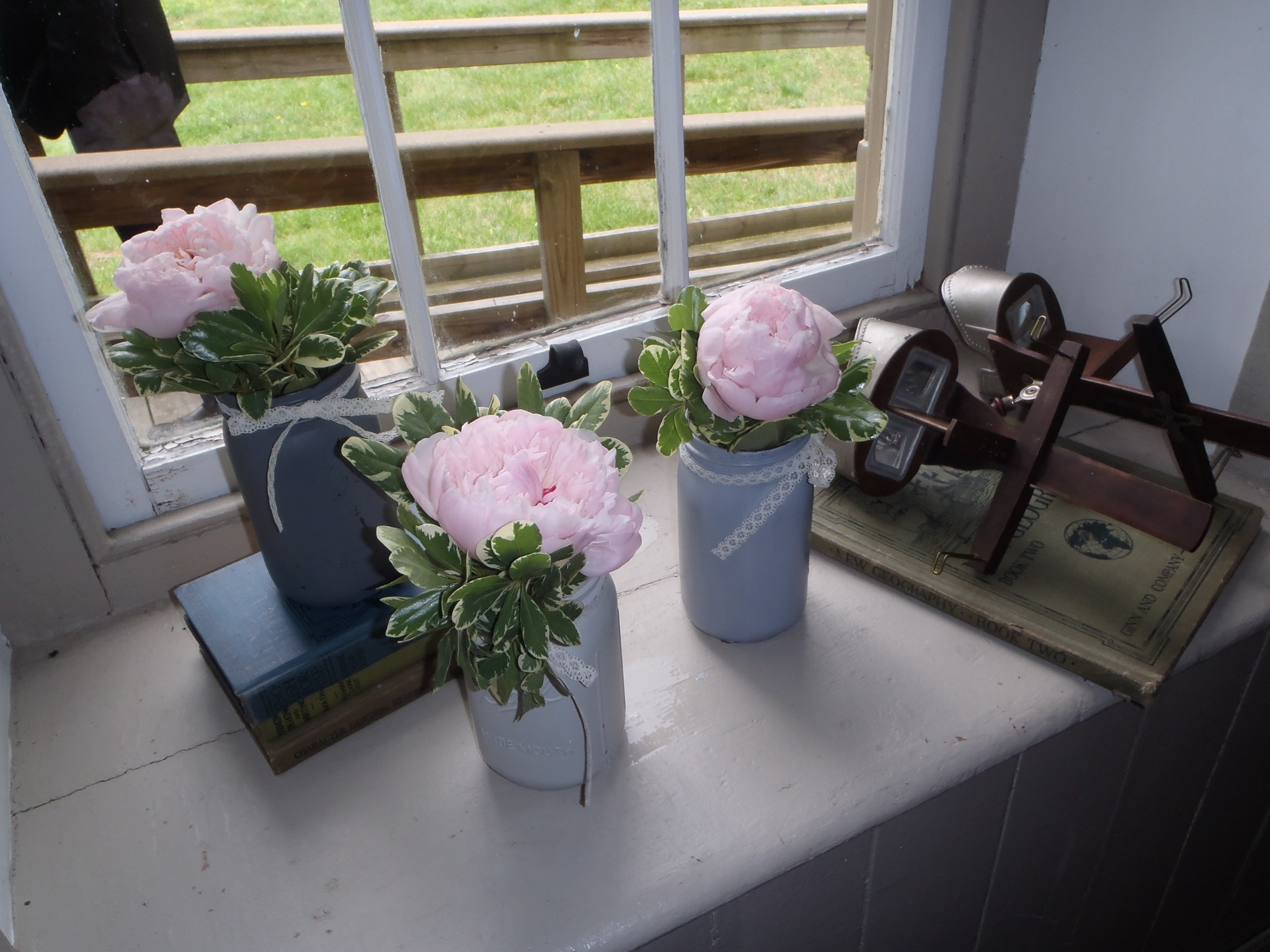 Peonies in mason jars placed on a windowsill for the wedding in the Lutz-Franklin Schoolhouse.