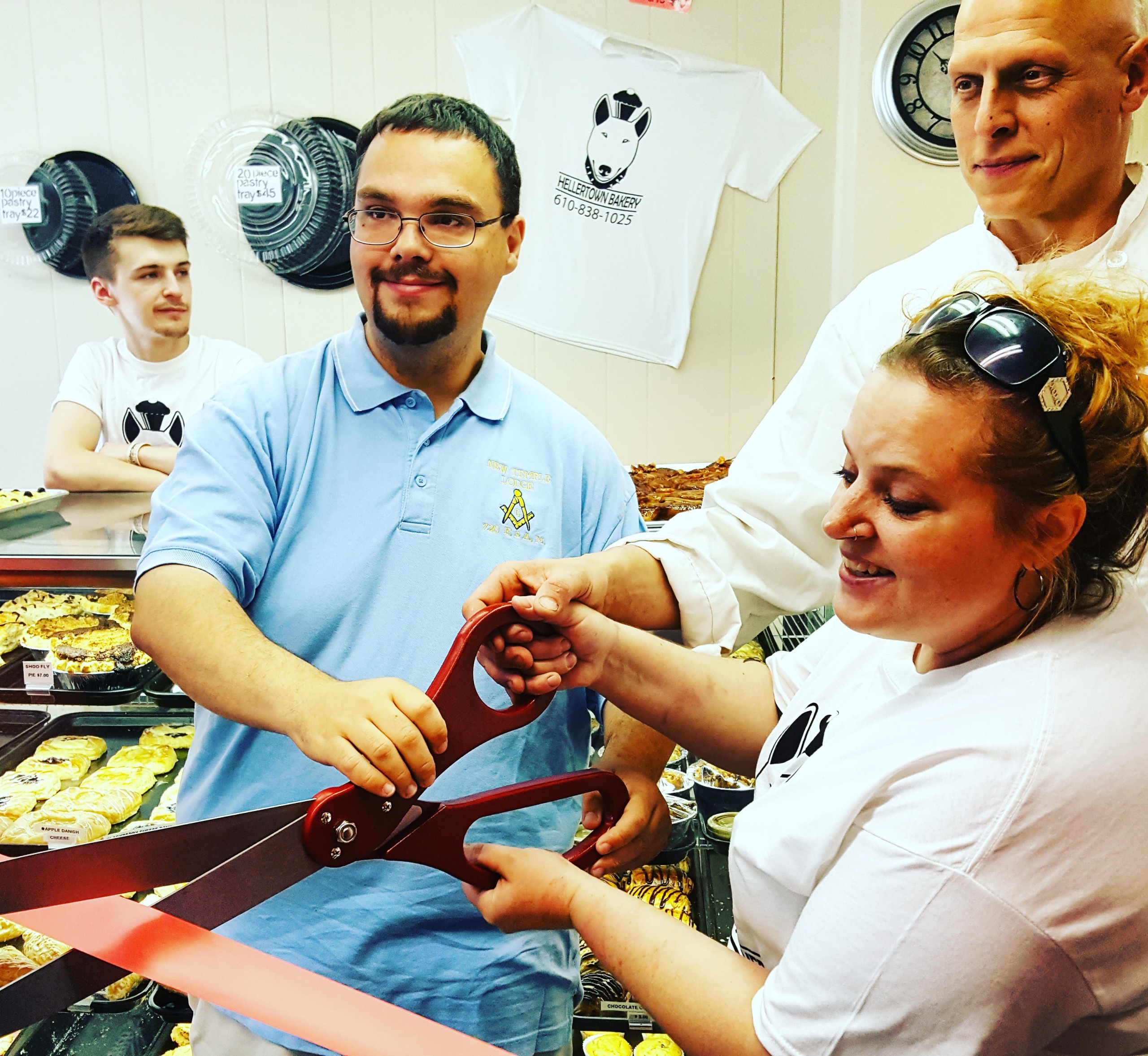 Hellertown-Lower Saucon Chamber of Commerce board chairman/borough council president Tom Rieger helps Hellertown Bakery owners Leiane McCarty and Joe Ciamprone cut the ribbon at their store Saturday morning. The bakery opened for business in early April.